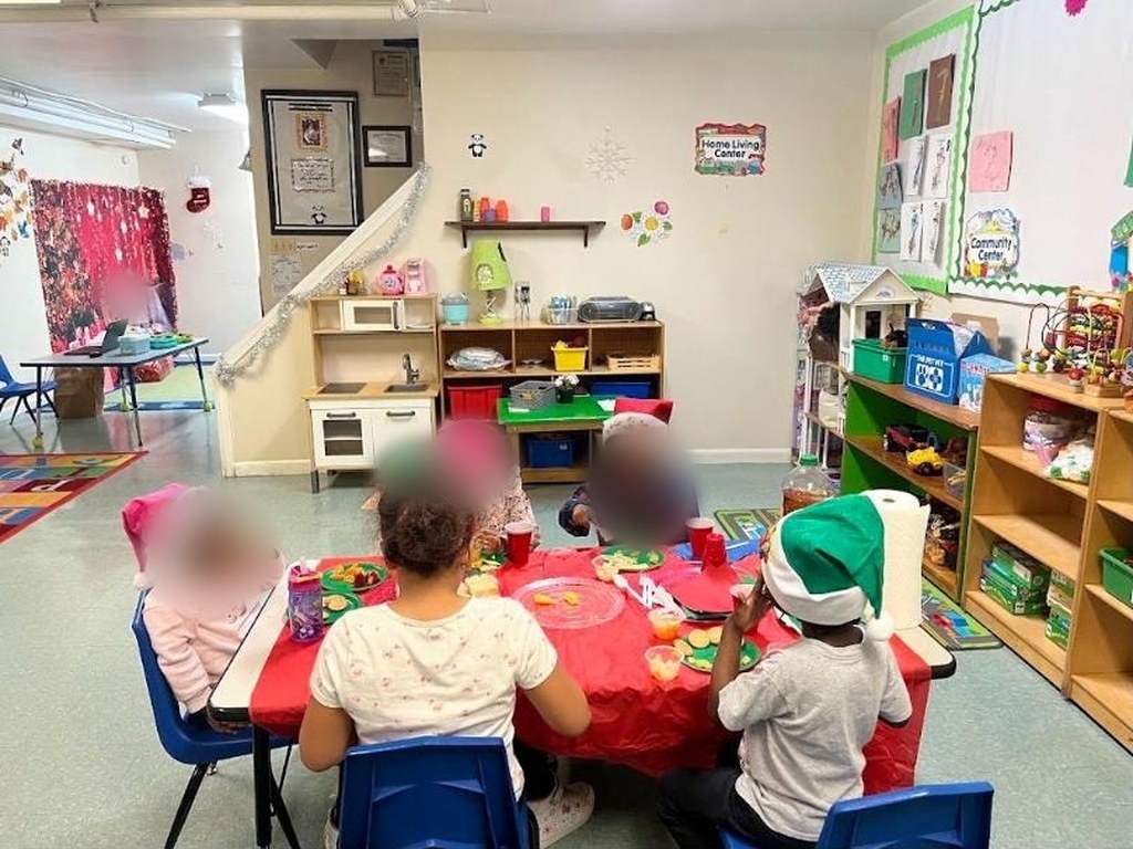 Christmas party in the decorated classroom with Santa hats and a red table