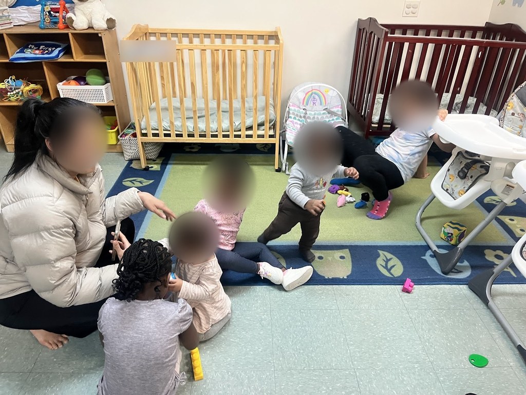 Toddlers playing on the classroom carpet with their teacher